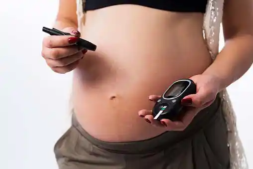  preganant woman monitoring her blood glucose level =